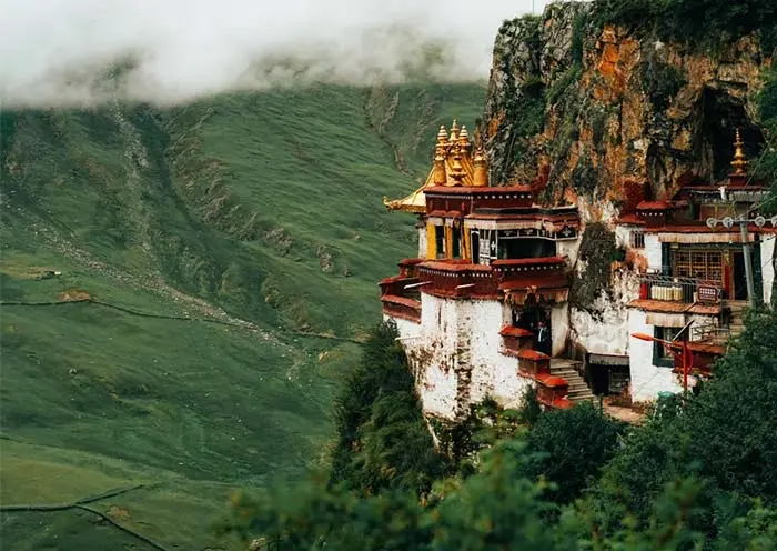 Drak Yerpa is a unique cliffside cave monastery near Lhasa. This image highlights the dramatic landscape and historical significance of Tibetan Buddhism hermitage sites.