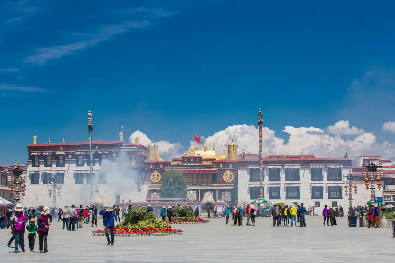The shimmering golden roofs of Jokhang Temple in Lhasa with the Potala Palace visible in the distance.