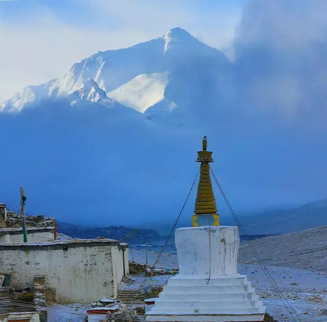 A white Tibetan stupa at Rongbuk Monastery with the North Face of Mt. Everest in the background.