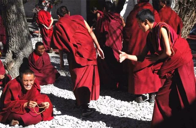 Tibetan monks engaged in energetic debating at the famous courtyard of Sera Monastery in Lhasa.
